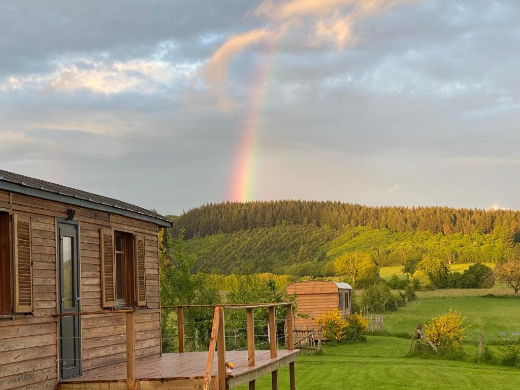 Roulottes des terres de la chouette的天上的一个彩虹,在一个带甲板的小屋上