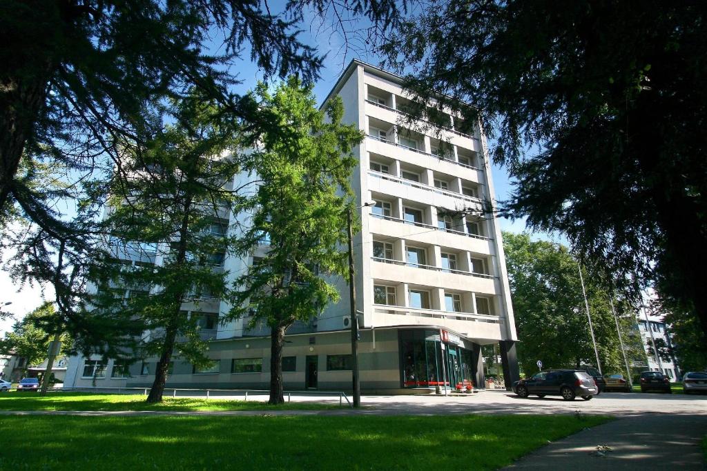 派尔努爱沙尼亚医疗温泉酒店 的前面有一辆汽车停放的白色建筑