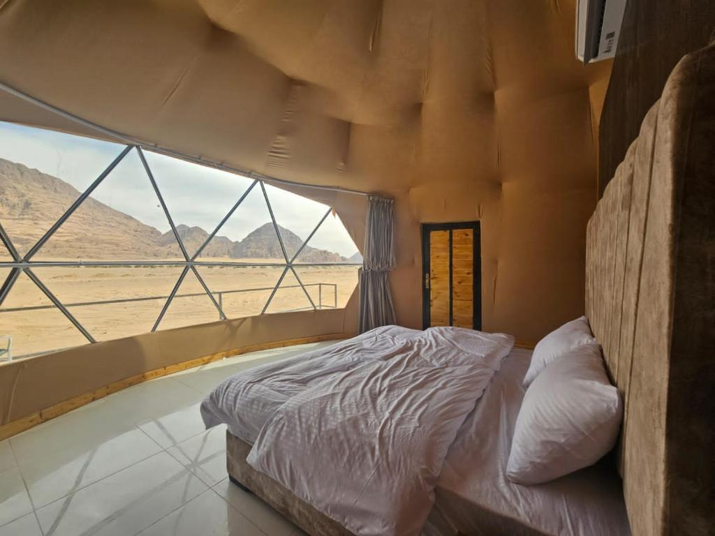瓦迪拉姆Salma Desert Camp的一张位于带大窗户的房间内的床铺