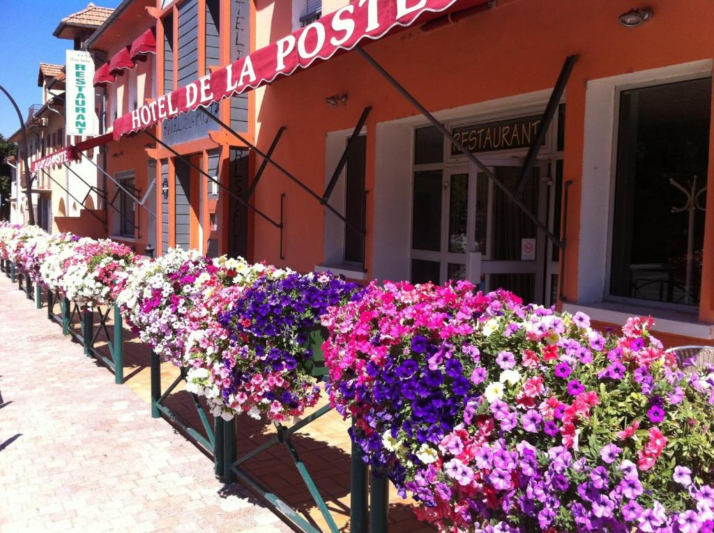 EspinassesHotel De La Poste的建筑物前的一排鲜花