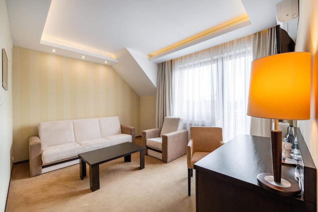 比亚沃维耶扎彼奥维斯基酒店/会议及康体中心/Spa的客厅配有沙发和桌子