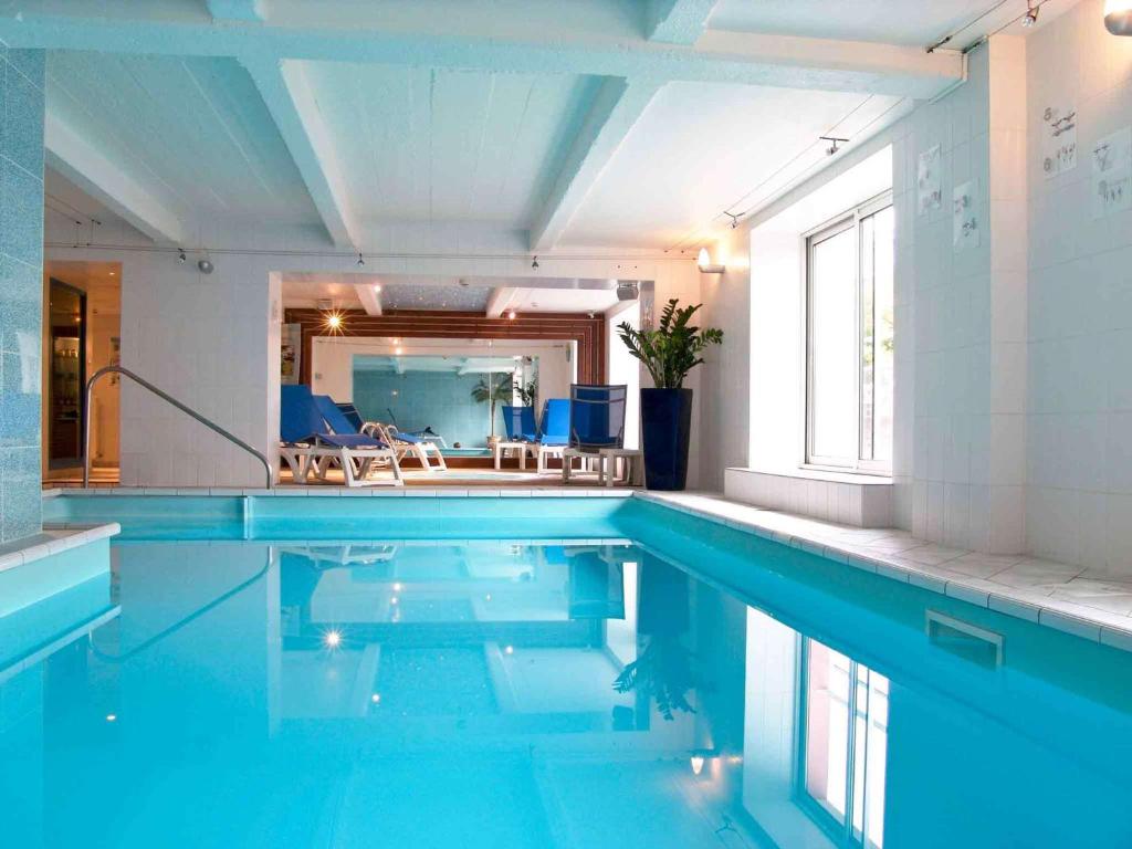 埃皮纳勒Mercure Epinal Centre的室内的蓝色海水游泳池