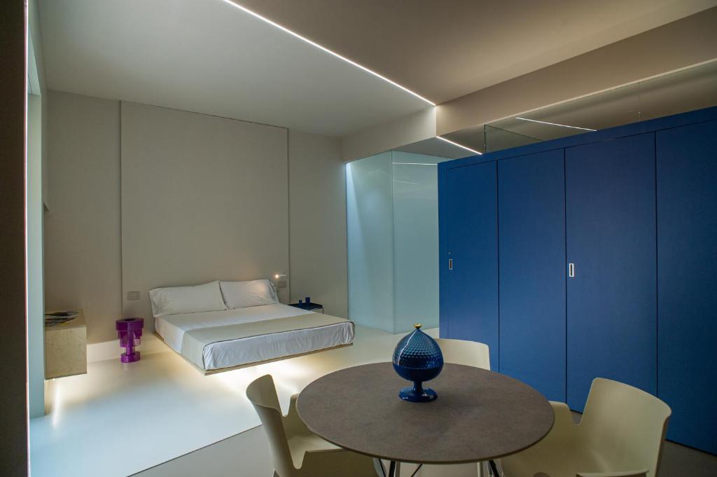 特拉帕尼Fiveplace Design Suites & Apartments的卧室配有一张床和一张桌子及椅子