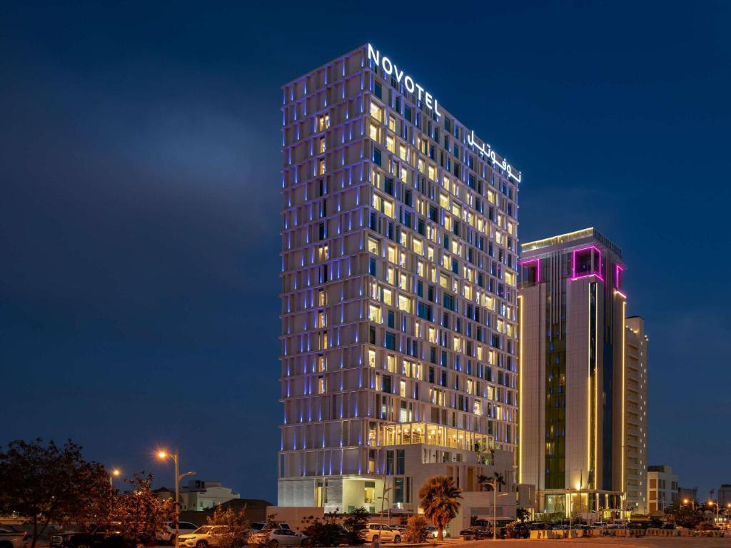 利雅德Novotel Riyadh Sahafa的一座高大的建筑,上面有标志