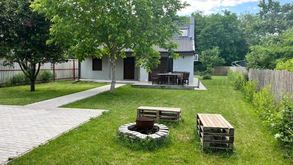 毛科Habitat of Dreams的一个带野餐桌、长凳和房子的院子