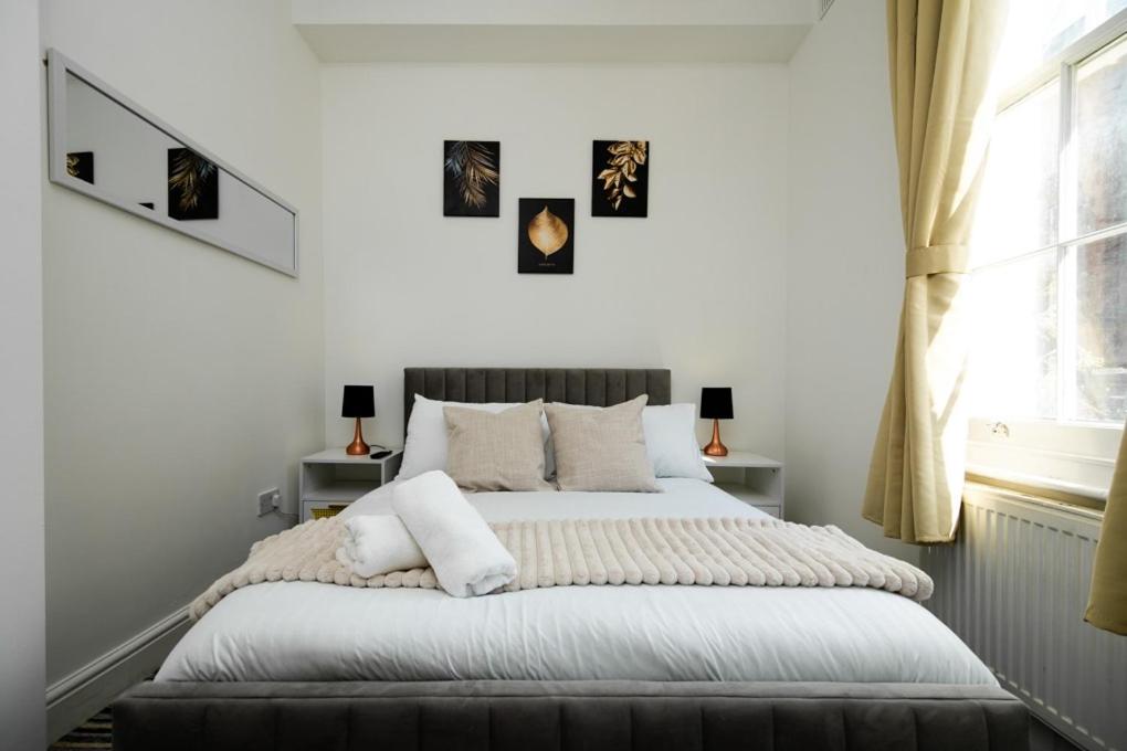 伦敦Islington Hideout的卧室配有带白色墙壁和窗户的床