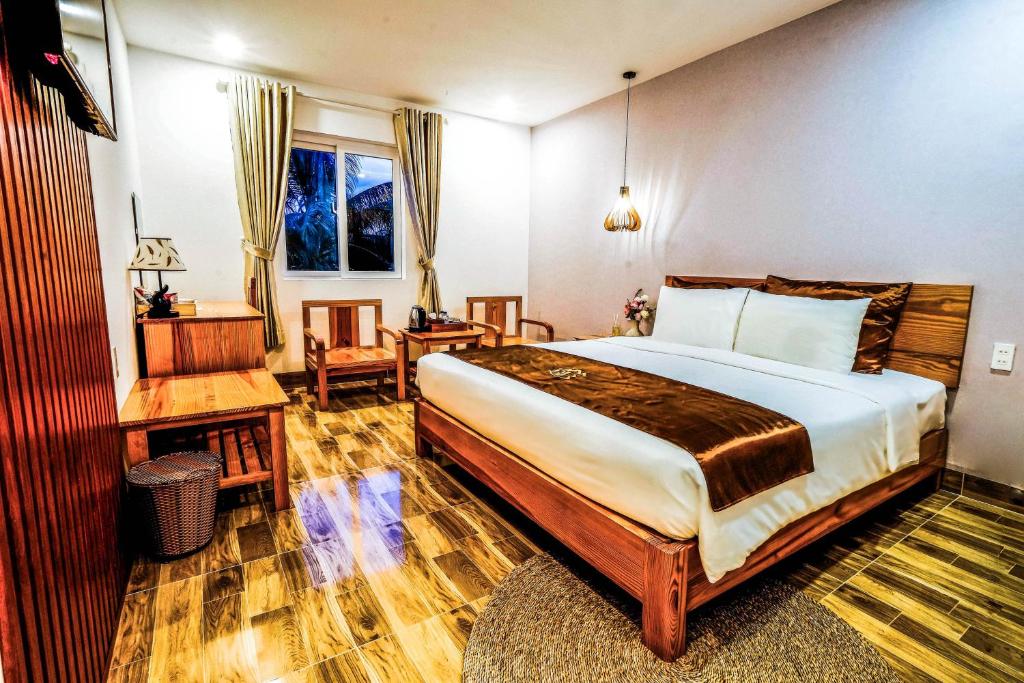 富国BB Hotel&Resort的一间卧室配有一张大床和一张桌子及椅子