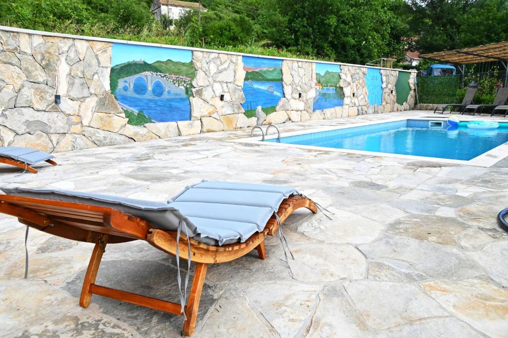 特雷比涅Gazdinstvo Vukanović - Kuća za odmor的墙上有躺椅的游泳池