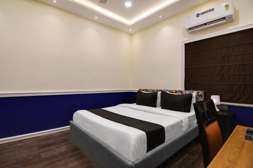 加尔各答OYO Hotel sakina的一间卧室设有一张蓝色墙壁的大床