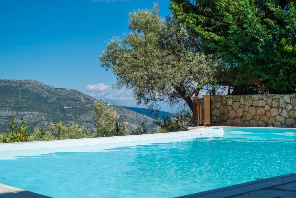 塞沃塔Arriva Villas的一座以树木和山脉为背景的游泳池