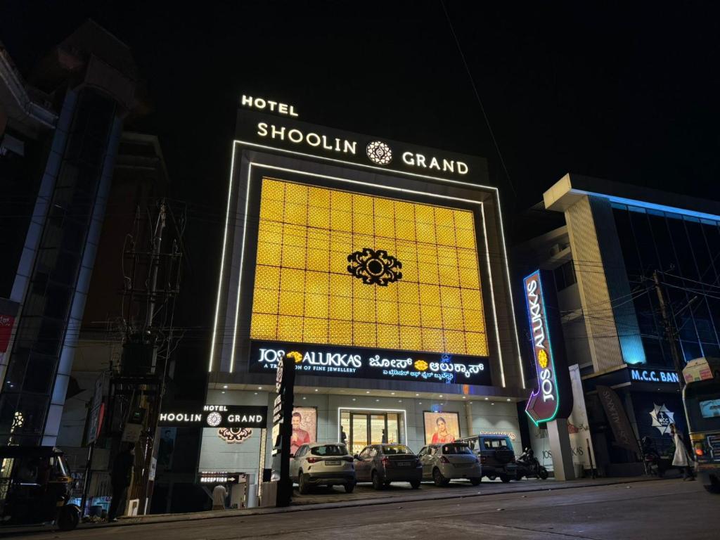 门格洛尔Hotel Shoolin Grand的前面有一个黄色大标志的商店