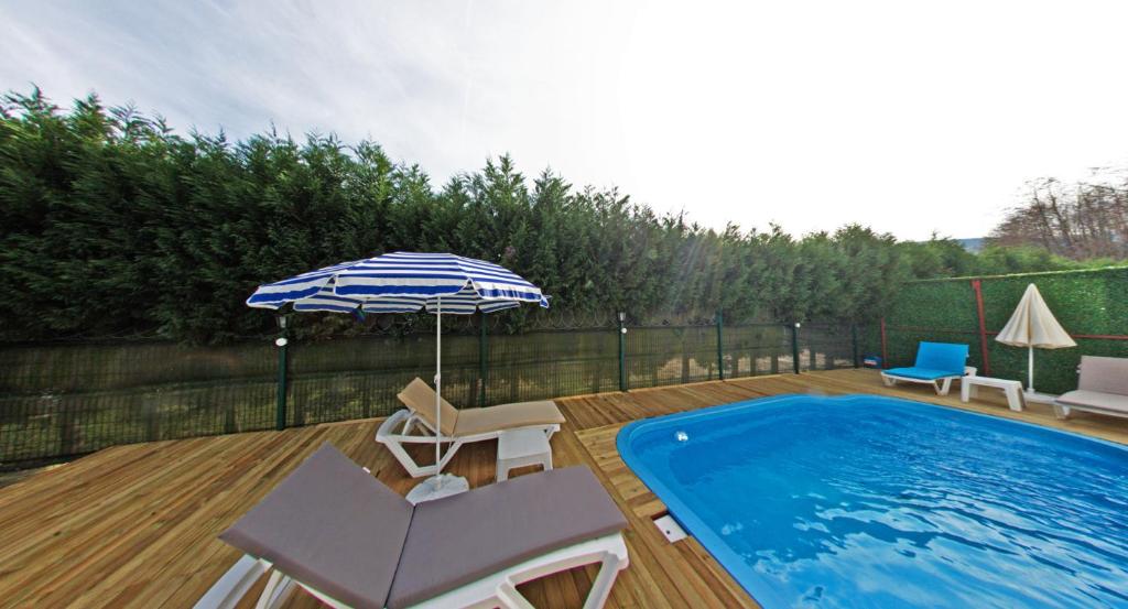 萨潘贾Sapanca Gönül Sofram Hotel & Bungalow & Villas的一个带游泳池、遮阳伞和椅子的庭院