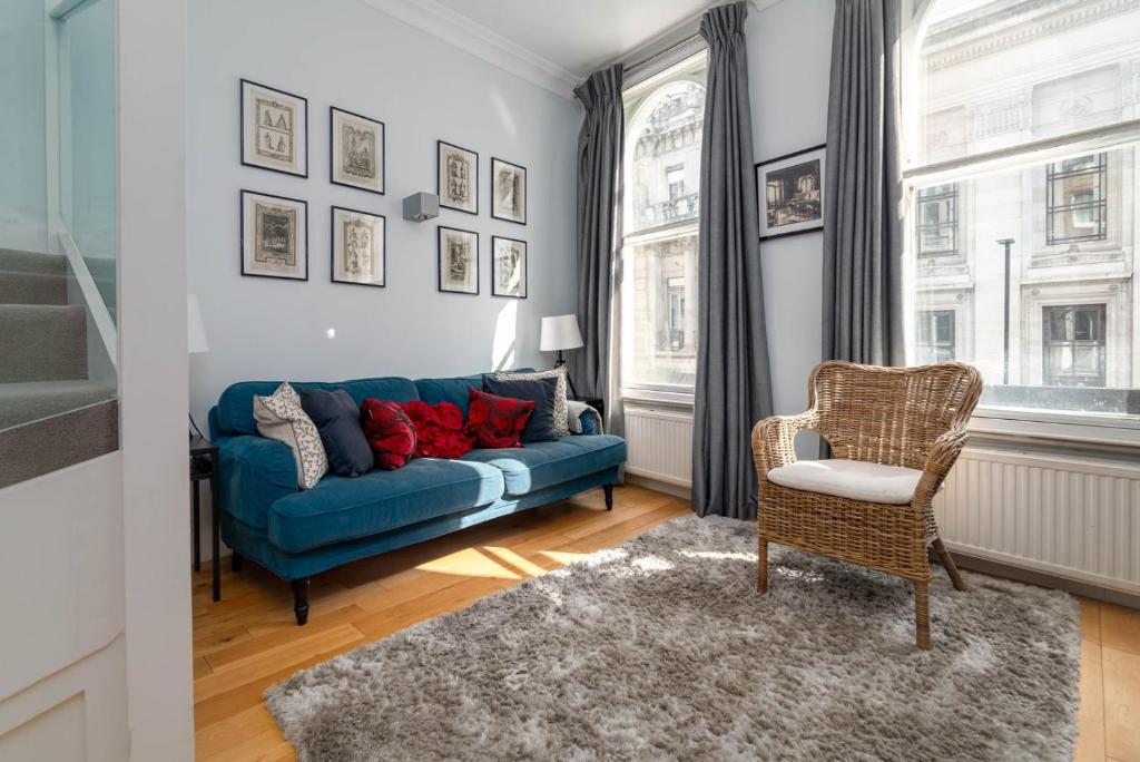 伦敦GuestReady - Stunning Covent Garden 2BR Duplex的客厅配有蓝色的沙发和椅子