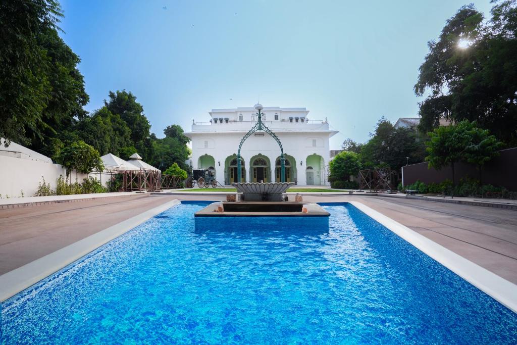 斋浦尔Diggi Palace - A City Center Hidden Heritage Gem的一座大楼前的游泳池,带喷泉