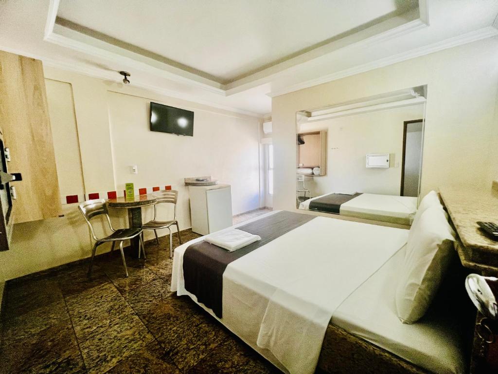 戈亚尼亚Hotel Buriti Shop的酒店客房设有两张床和一张桌子。