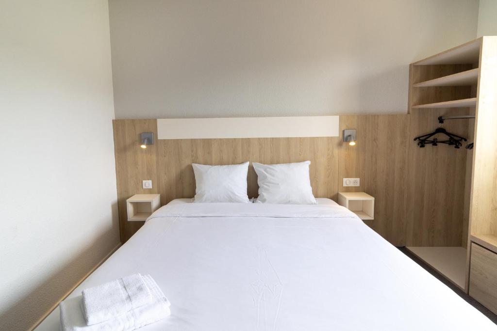 阿普瓦尼Kyriad Direct Auxerre - Appoigny的卧室配有一张带两个枕头的大白色床