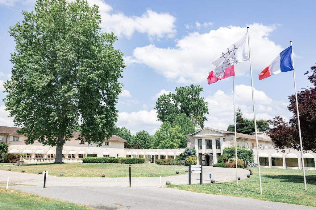 马尔戈Relais de Margaux - Hôtel & Spa的建筑物前悬挂三面旗帜