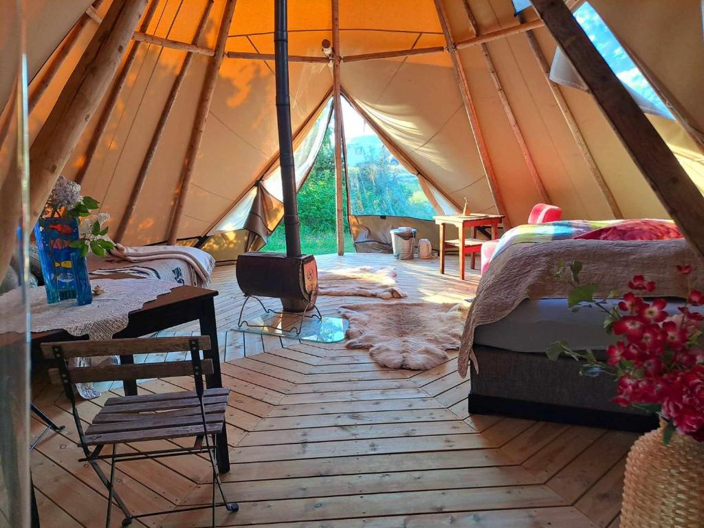 MelhusStrandheimen Guesthouse的帐篷配有两张床和木地板