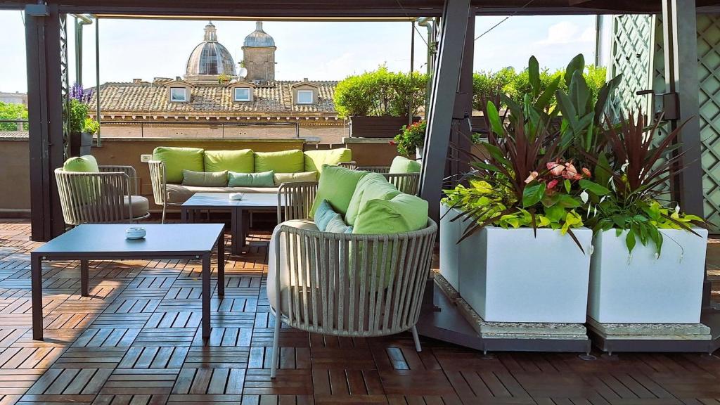 罗马Hotel Indigo Rome - St. George, an IHG Hotel的庭院设有桌椅和植物