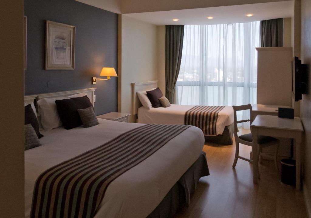 卡塔马卡卡塔马卡公园酒店的酒店客房设有两张床、一张书桌和一个窗户。