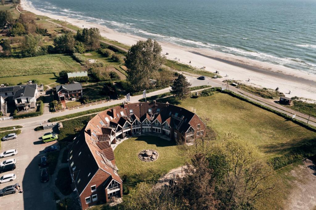 克隆斯加尔德Ferienwohnung "Ostseeperle" direkt am Ostseestrand的海滩旁房屋的空中景致