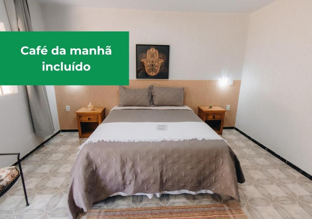 戈亚斯州上帕莱索Hotel Fazenda Bona Espero的一间有绿色标志的房间的一张床位,上面写着一个读马尼拉小咖啡馆的标志