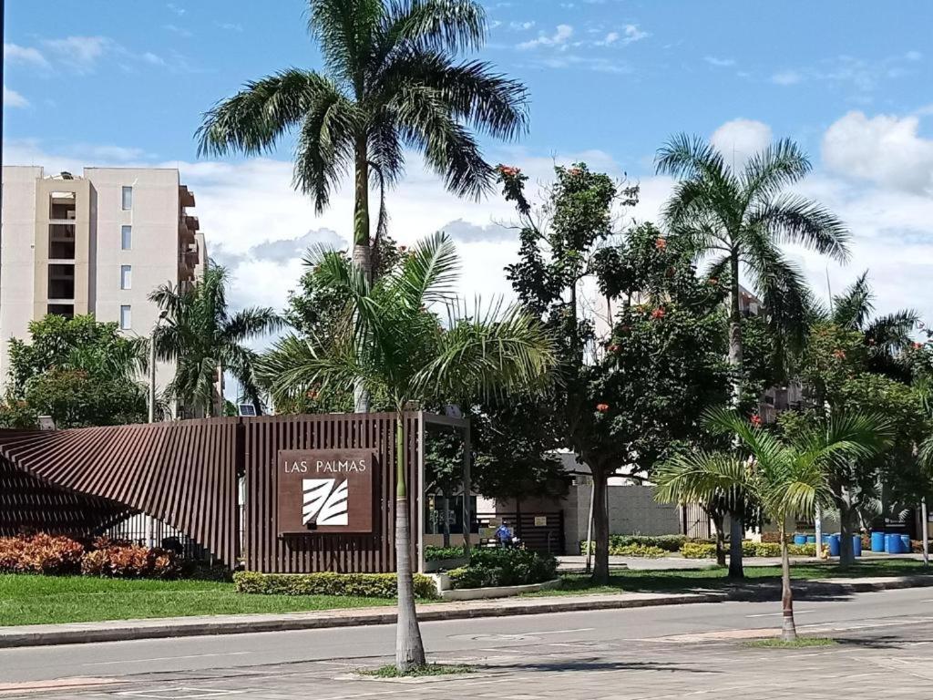 里考尔特Apartamento Hacienda Peñalisa的棕榈树建筑前的标志