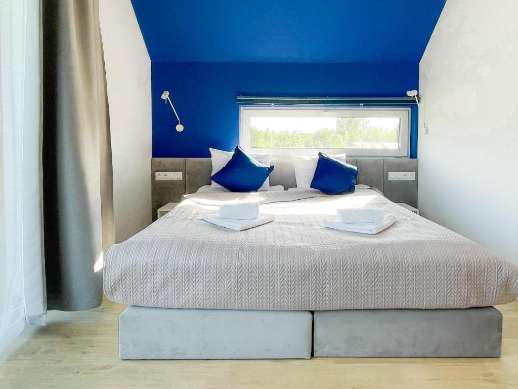 米泽德沃兹Między Wodami的一间卧室配有一张带蓝色墙壁的大床