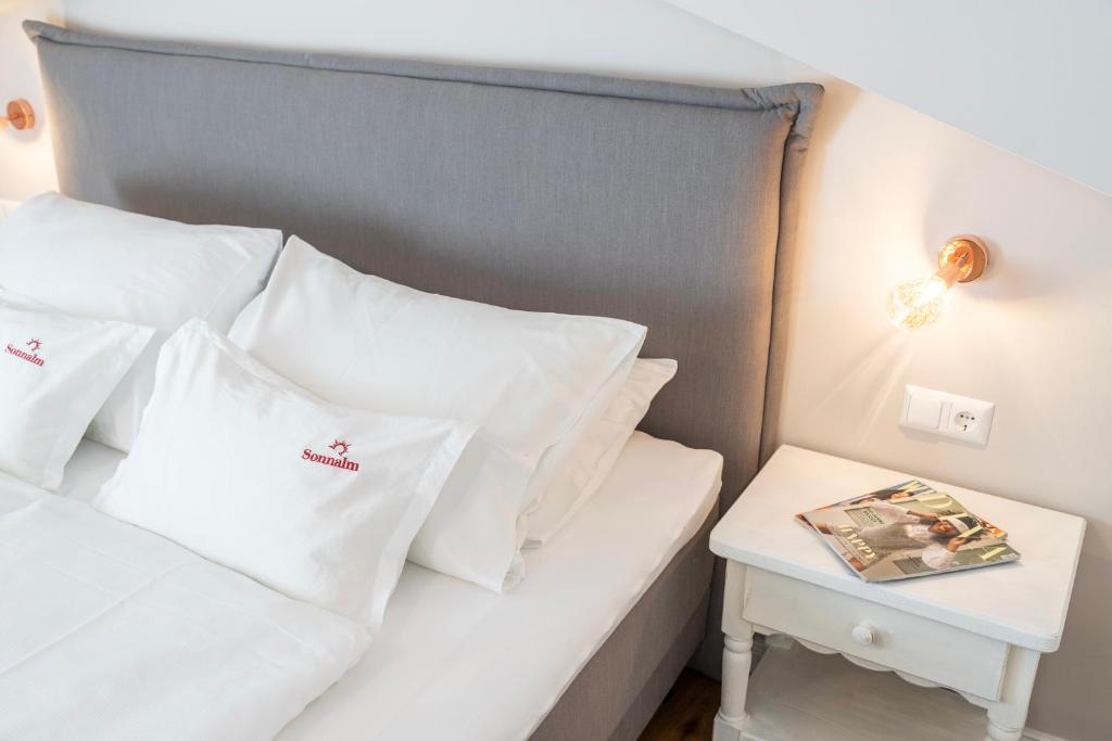 巴德小基希海姆松纳尔姆酒店的一张带白色枕头和边桌的床