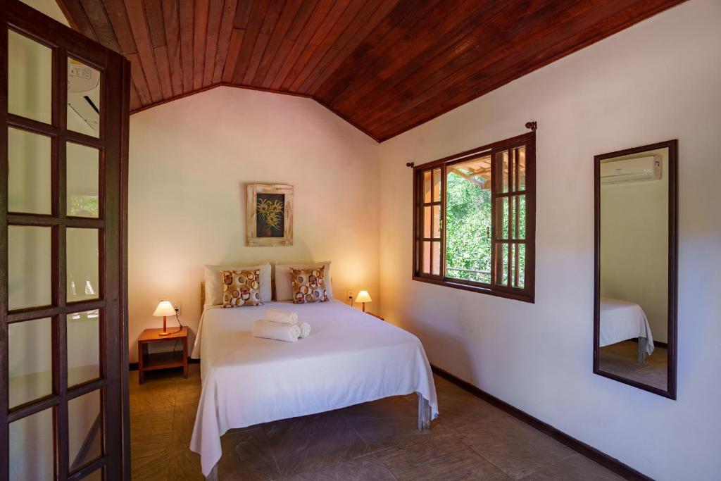 布希奥斯Pousada Casa Cactus Praia da Tartaruga Búzios的卧室配有白色的床和窗户。