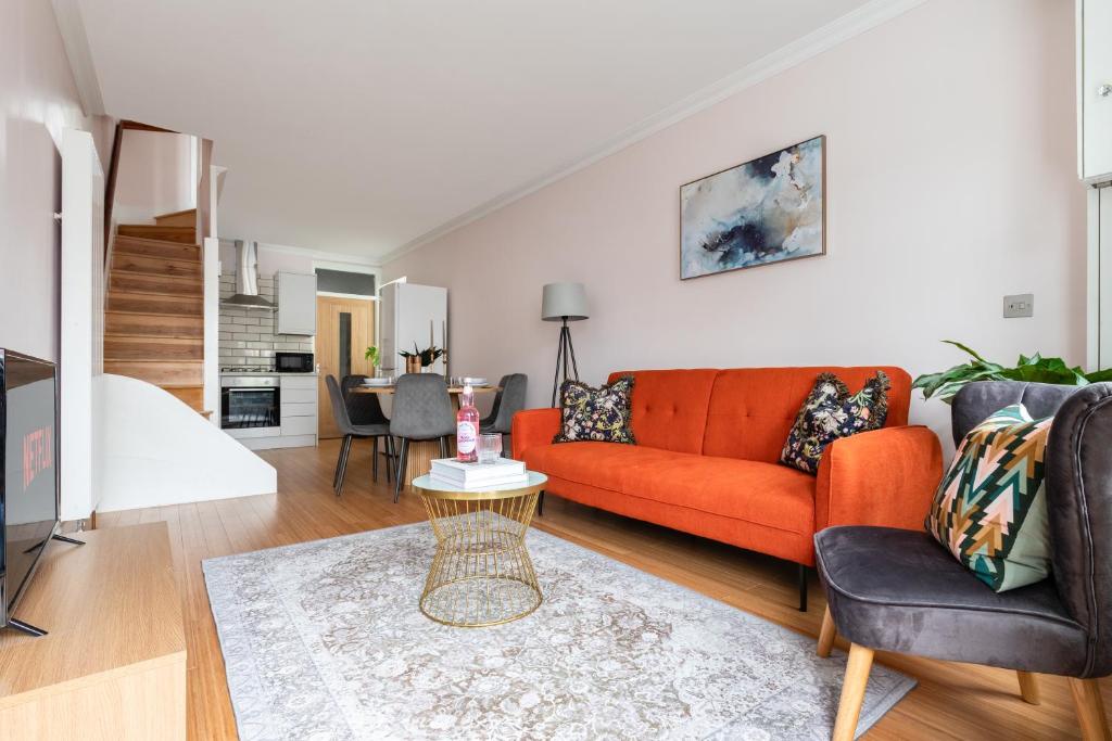 Streatham ValeCute, Stylish House w/ fast wifi的客厅配有橙色沙发和桌子
