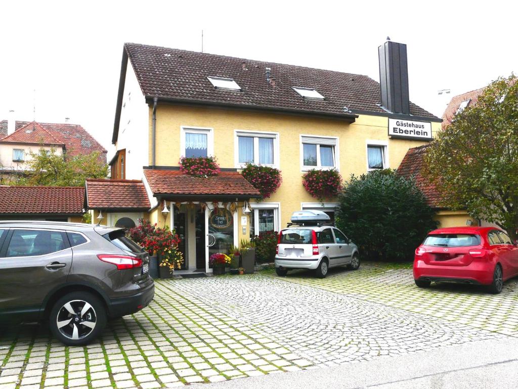 罗滕堡埃伯莱因格斯特豪斯酒店的两辆汽车停在房子前面