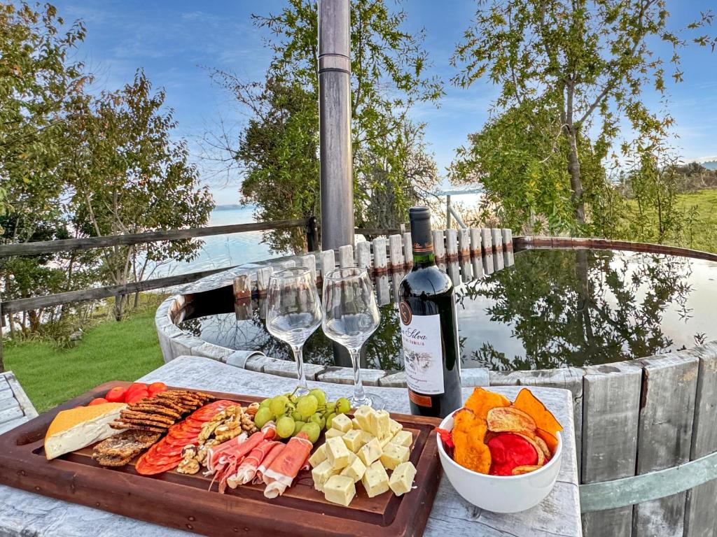 普耶韦Orilla de Lago con Hot Tub, parrilla y vistas的一张桌子,上面放着一个食品和酒杯托盘