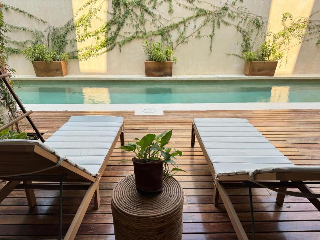 埃斯孔迪多港Casa Ita Surf - Adults Only的一个带两把椅子的庭院和一个游泳池