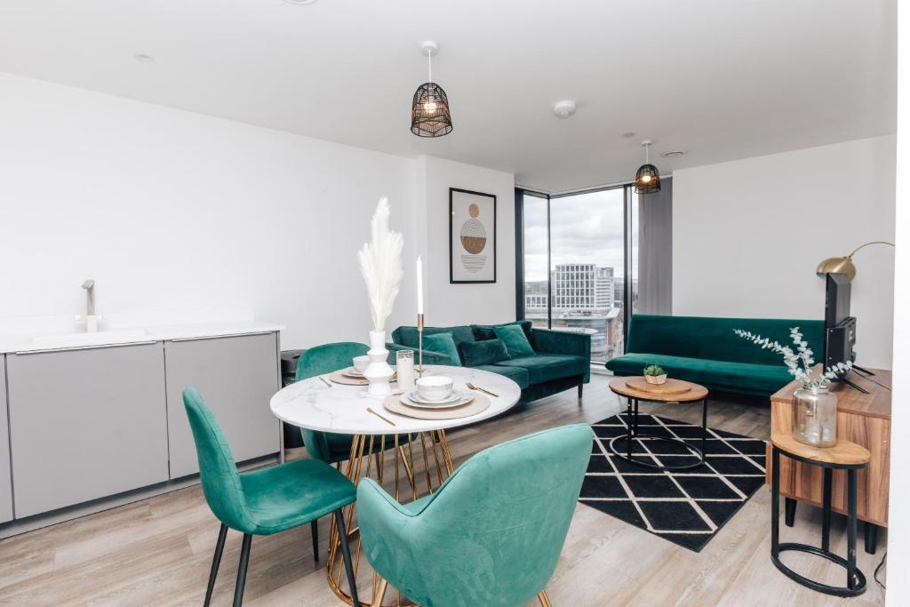 伯明翰Luxury 2 Bedroom Apartment, Broad street Birmingham的客厅配有桌子和绿色椅子