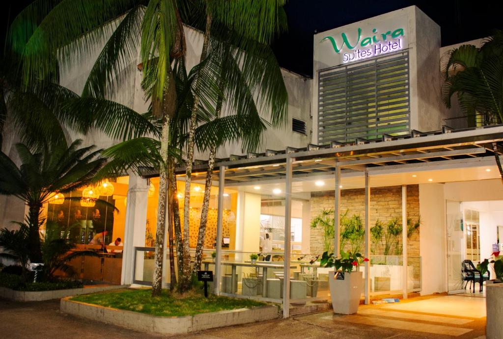 莱蒂西亚怀拉套房酒店的前面有棕榈树的商店