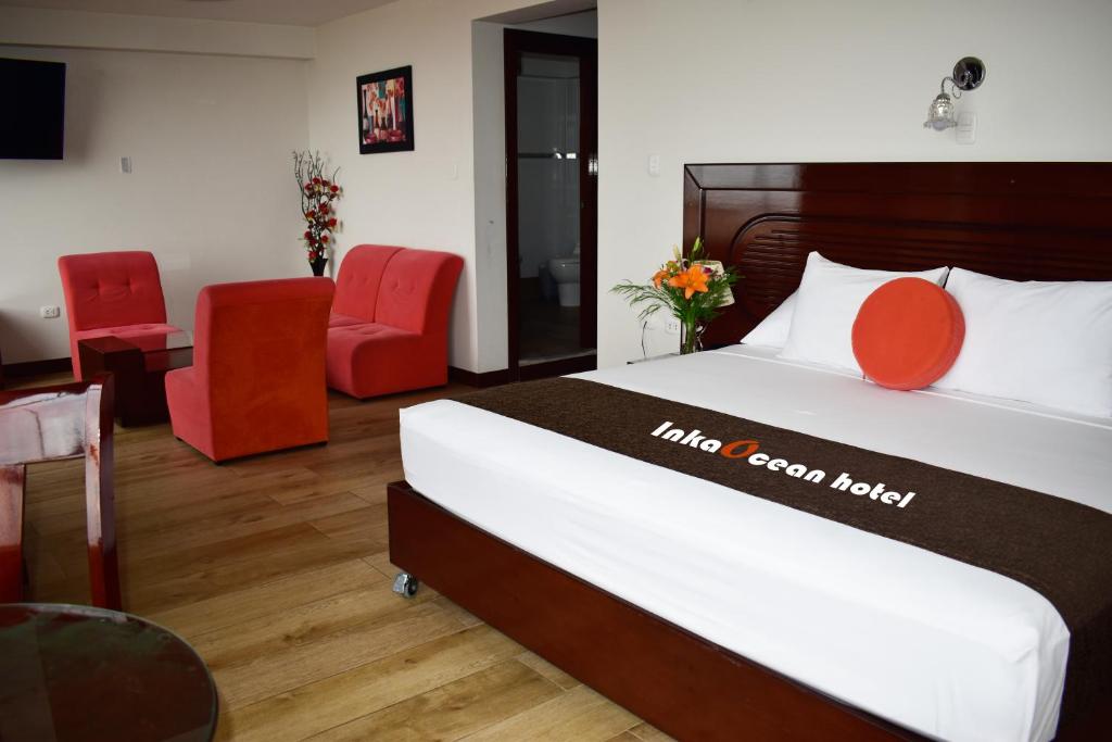 伊洛InkaOcean Hotel的酒店客房,配有床铺和红色椅子