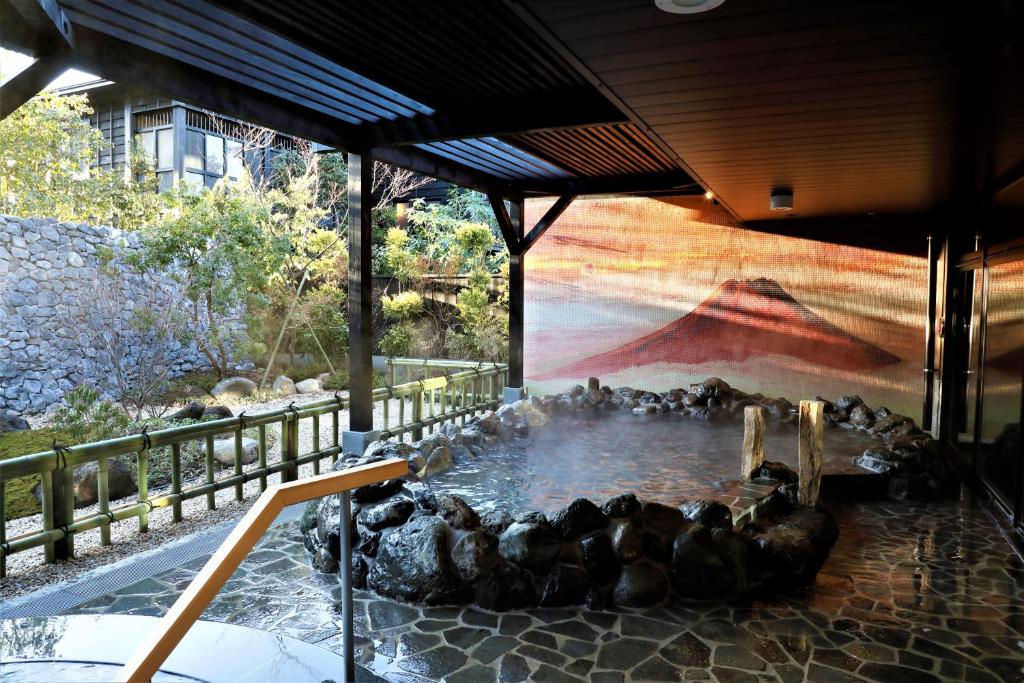 箱根Hotel Morinokaze Hakone Sengokuhara的一群鸭子在一座建筑物的池塘里