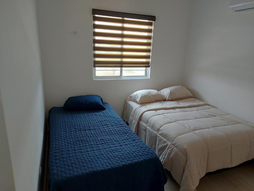 蒙特雷Alojamiento Entero Monterrey Airport的一间卧室设有两张床和窗户。