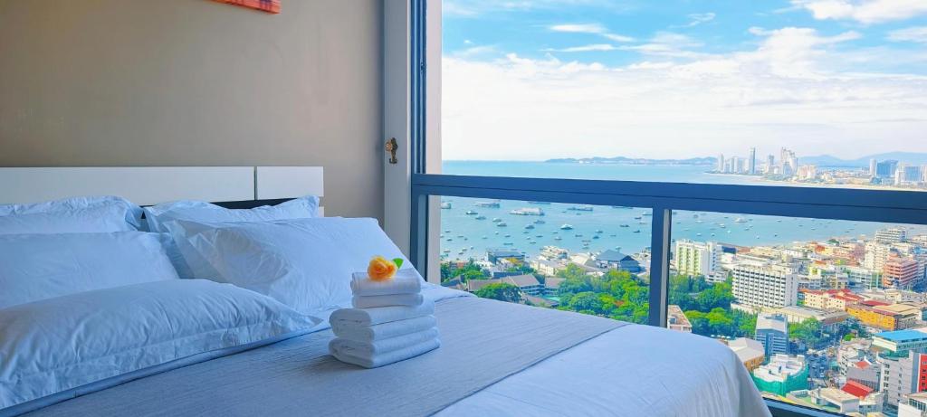 南芭堤雅South Pattaya Condo delux sea view near walking street的卧室设有白色的床和大窗户