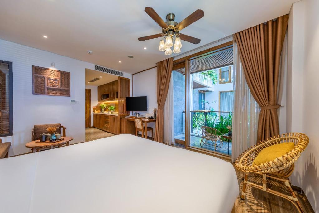 岘港Bonny Boutique Hotel Da Nang的一间卧室配有一张床和吊扇