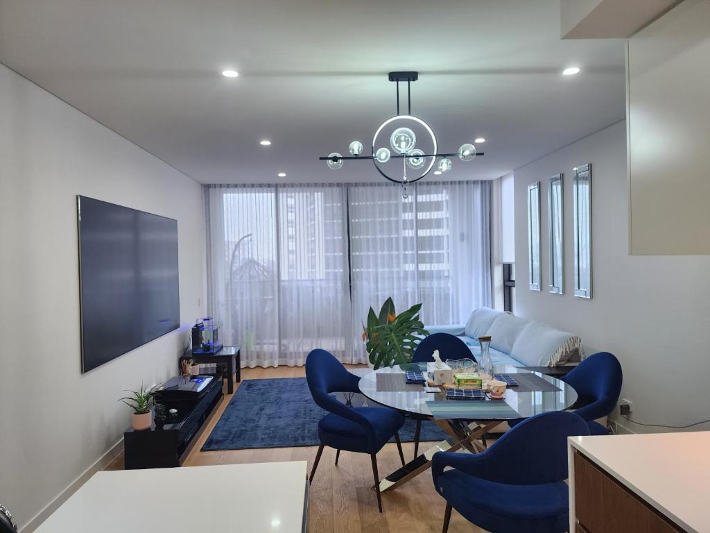 悉尼CBD Parramatta shared apartment, swimming pool and gym,internet的客厅配有桌子和蓝色椅子