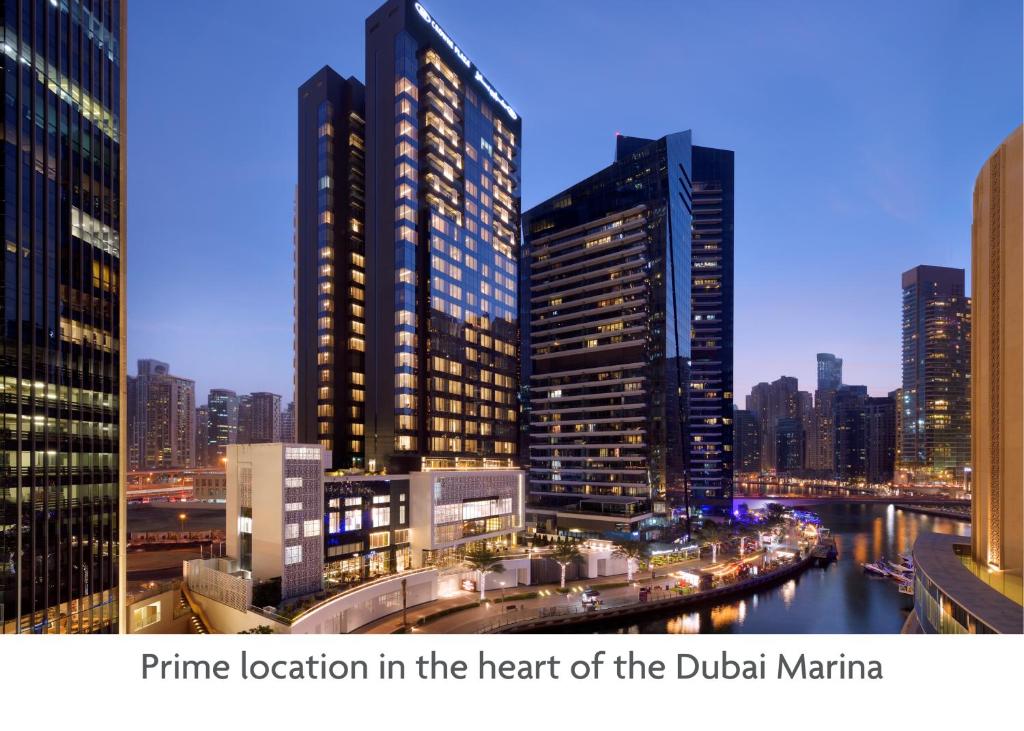 迪拜Crowne Plaza Dubai Marina, an IHG Hotel的享有夜间城市景观和建筑