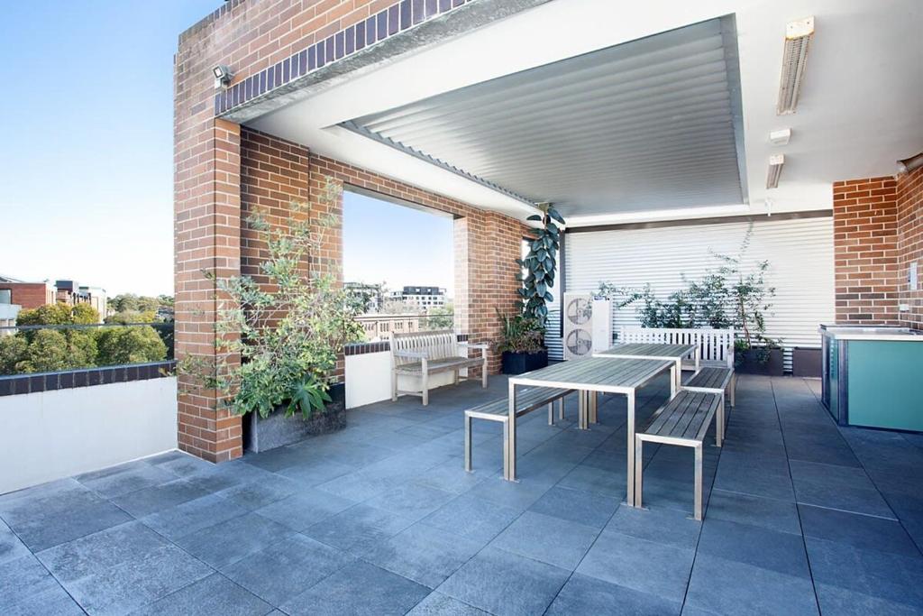 悉尼Stylish Studio with Balcony near Darling Square的大楼内带桌椅的天井