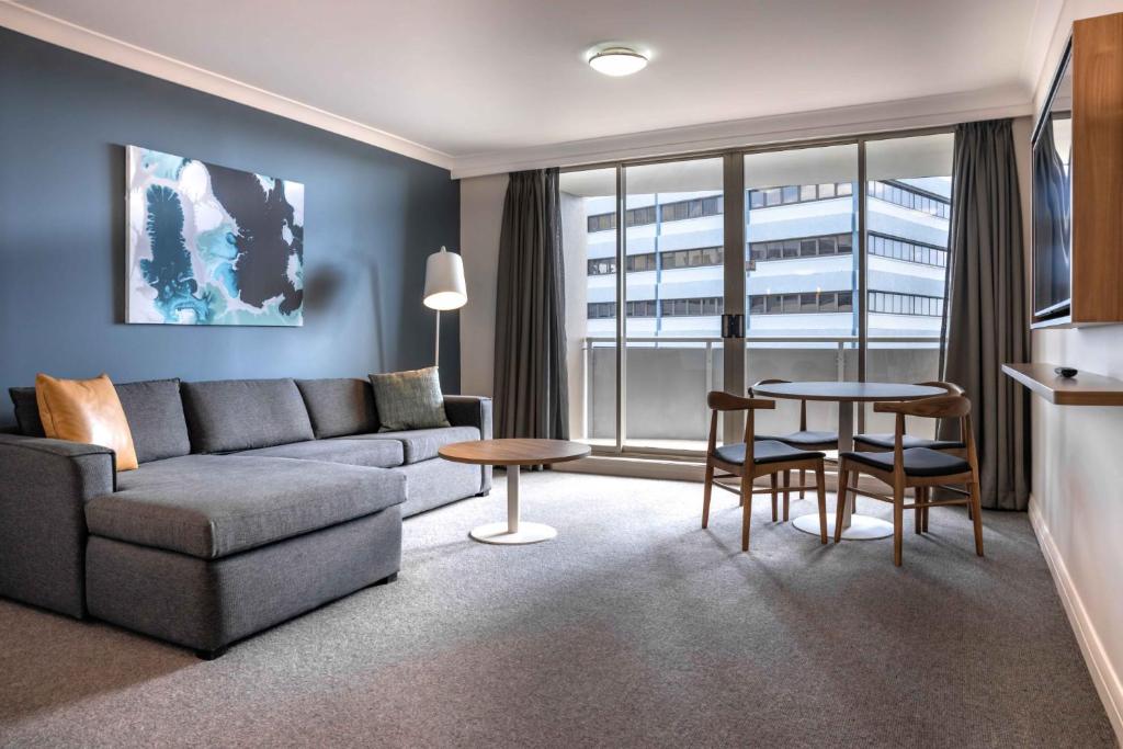 悉尼Central 1-Bed with Parking, Pool, Sauna & Gym的客厅配有沙发和桌子
