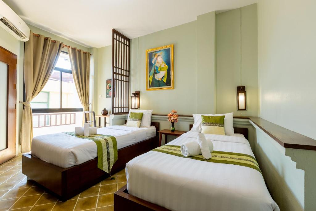 清迈清迈萱格旅馆的酒店客房设有两张床和一个阳台。