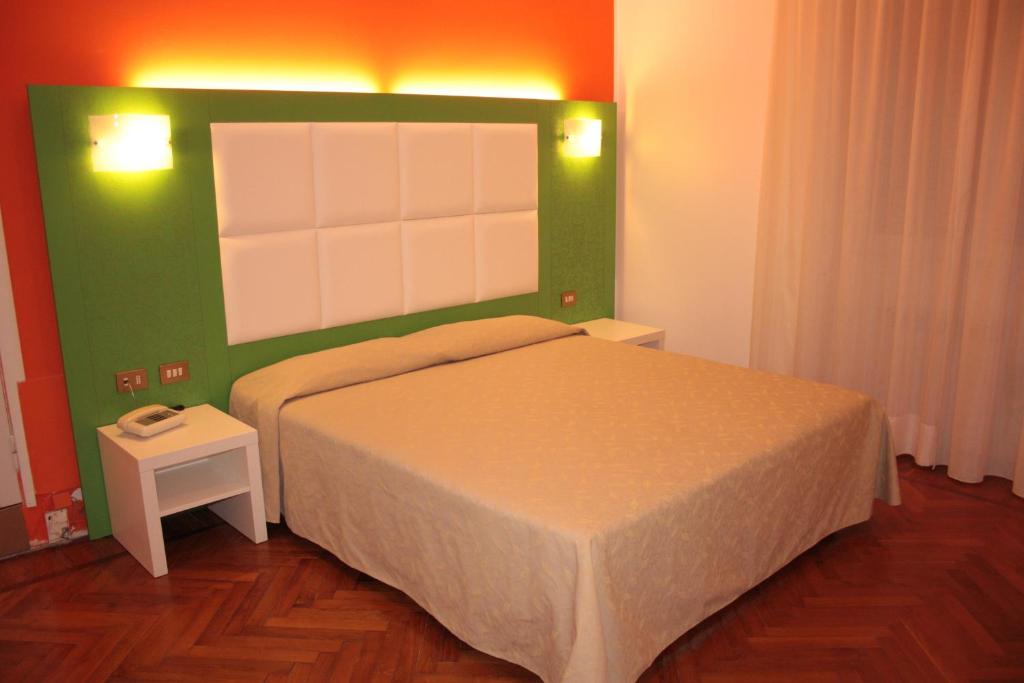 斯特雷萨马泽尼大街住宅酒店的一间卧室设有一张床和绿色的墙壁