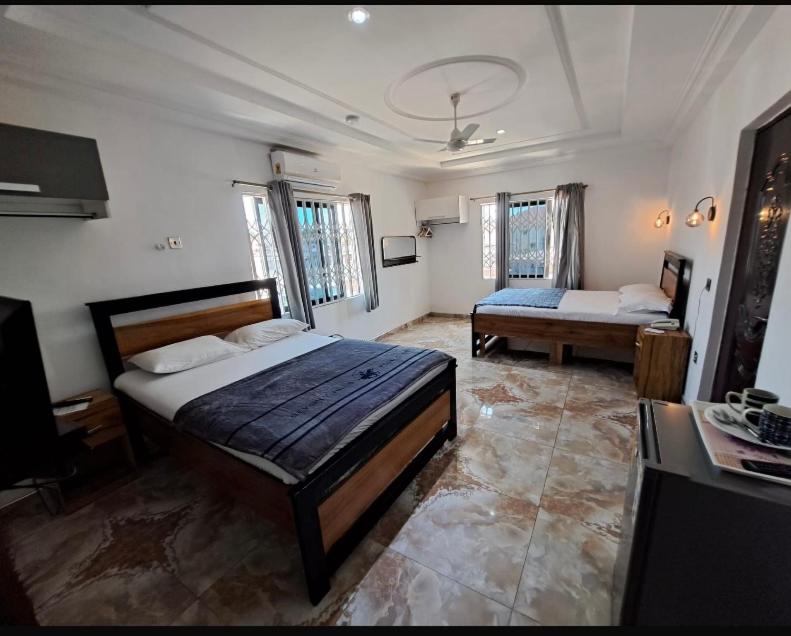 AdiebabaBAFFOUR APARTMENTS的一间卧室配有两张床和电视。