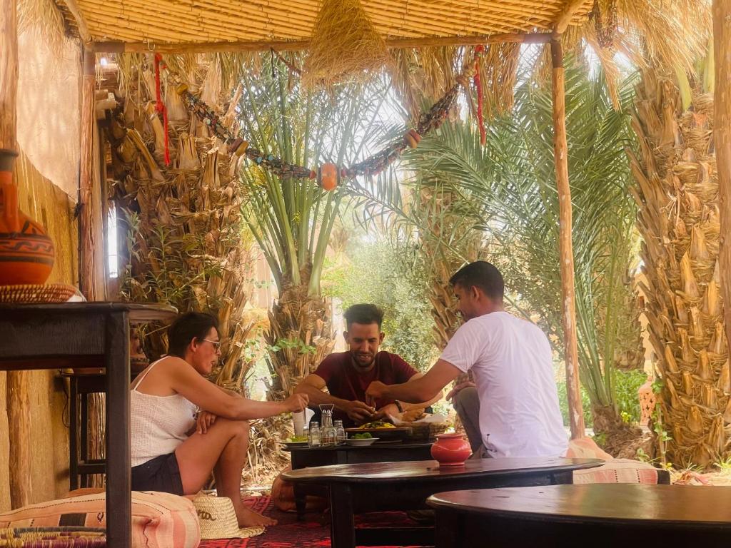 扎古拉Zagora Oasis Lodge的一群坐在餐厅桌子上的人