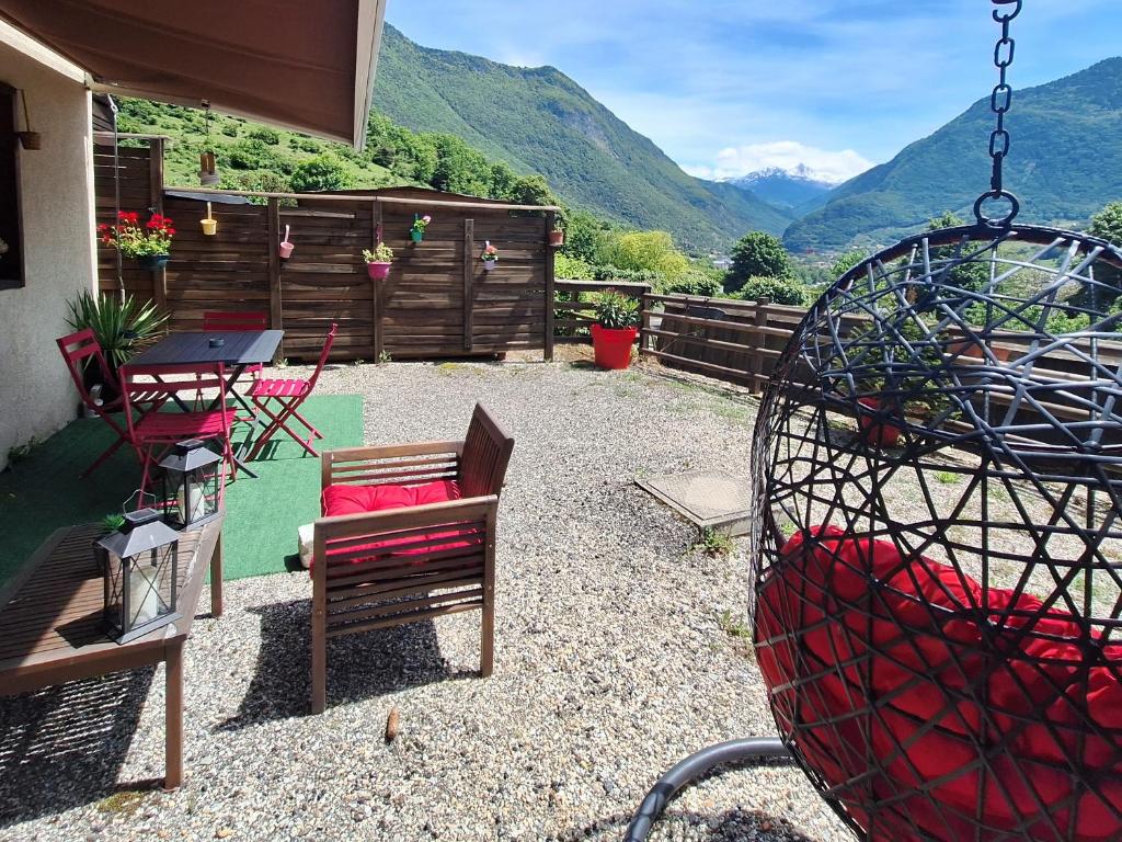 AigueblancheAppartement avec terrasse et parking Privé的庭院配有椅子和桌子,后面是山脉